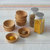 Small condiment cups are stacked, with 2 cups in the foreground that hold spices.