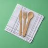 A set of Bamboo Cutlery is laid on a white and blue napkin.