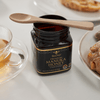 A bamboo teaspoon rests on a jar of Manuka Honey. bambu