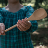 A person in a blue checkered shirt holds a bamboo Spoontula out.