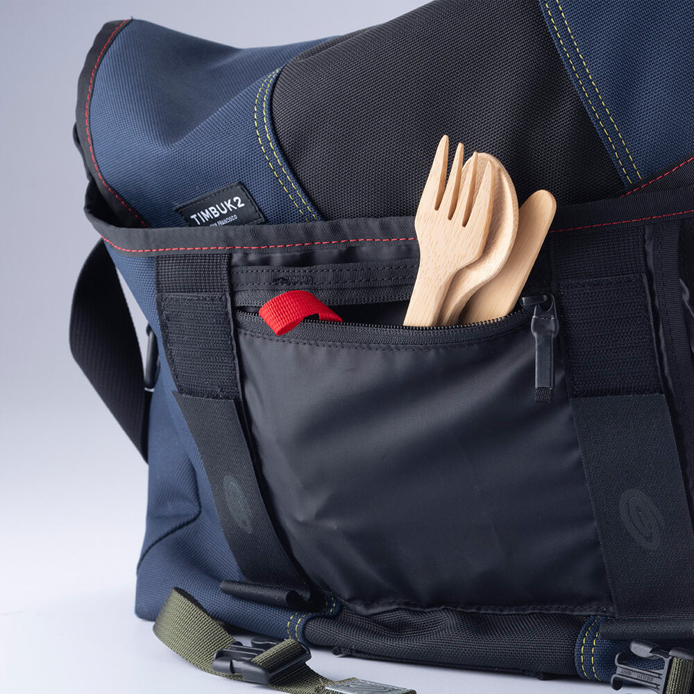 A Bamboo Spoon, Knife & Fork set are tucked into a pocket on the front of a messenger bag.